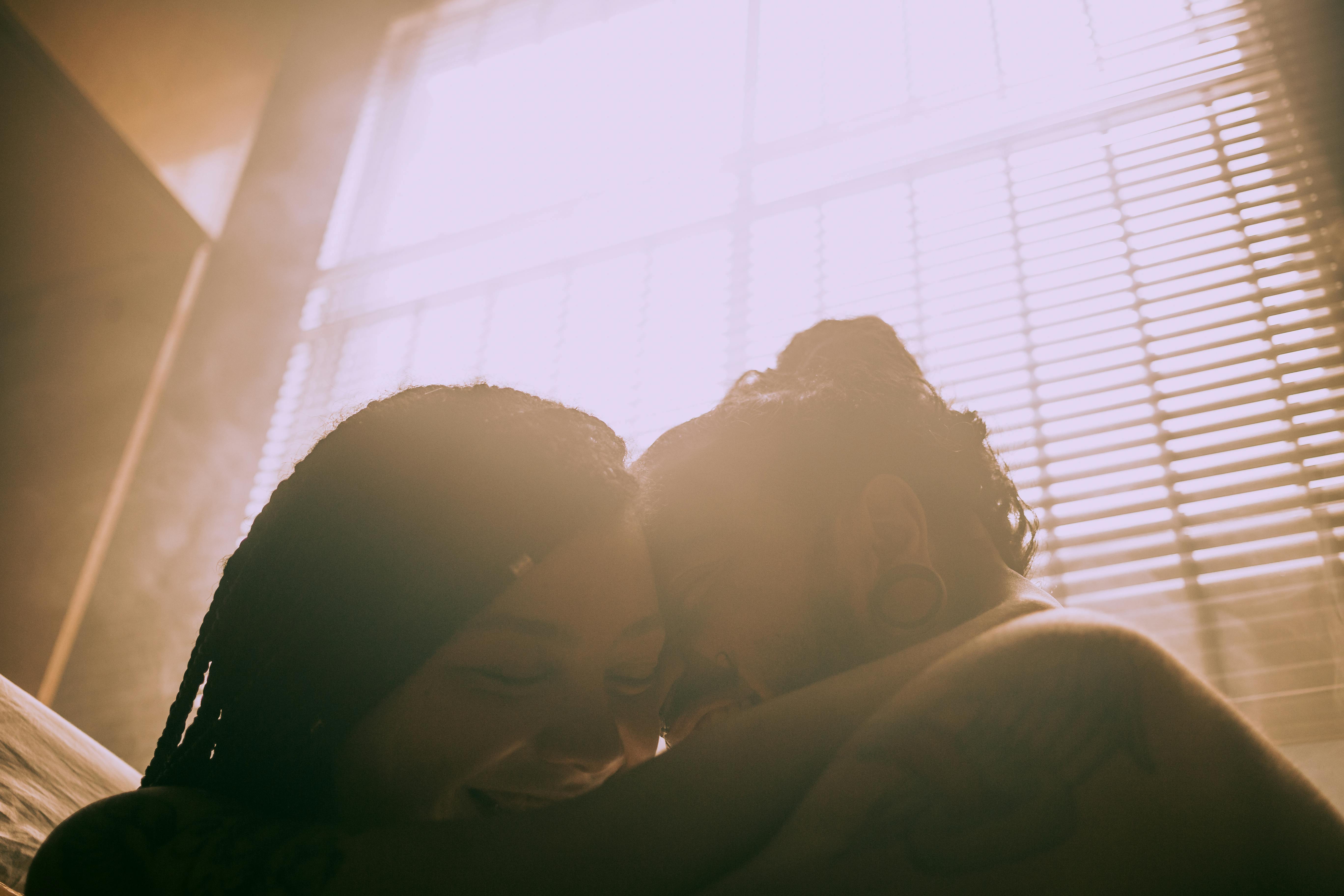 Couple in warm backlight, foreheads together in an intimate moment